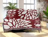 Fiesta Floral Cotton Throw Blanket in Red, draped over a sofa