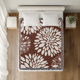 Fiesta Floral Cotton Throw Blanket in Rust Brown, on a bed
