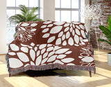Fiesta Floral Cotton Throw Blanket in Rust Brown, draped over a sofa