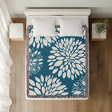 Fiesta Floral Cotton Throw Blanket in Turquoise, on a bed