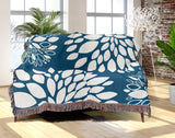 Fiesta Floral Cotton Throw Blanket in Turquoise, draped over a sofa