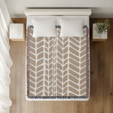 Freda Hand Woven Throw Blanket in Beige, on a bed