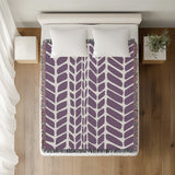 Freda Hand Woven Throw Blanket in Purple, on a bed