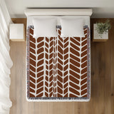Freda Hand Woven Throw Blanket in Rust Brown, on a bed