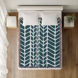 Freda Hand Woven Throw Blanket in Teal, on a bed