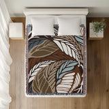 Gabo Floral Cotton Throw Blanket in Beige, on a bed