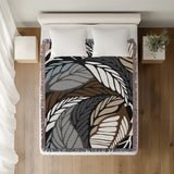 Gabo Floral Cotton Throw Blanket in Black, on a bed