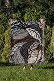 Gabo Floral Cotton Throw Blanket in Black, draped over a sofa