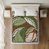 Gabo Floral Cotton Throw Blanket in Green, on a bed