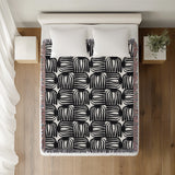 Hami Cotton Throw Blanket in Black, on a bed