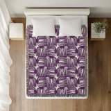 Hami Cotton Throw Blanket in Purple, on a bed