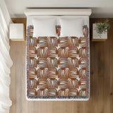 Hami Cotton Throw Blanket in Rust Brown, on a bed