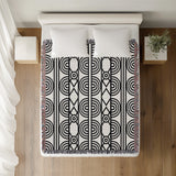 Idia Geometric Cotton Throw Blanket in Black, on a bed