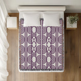 Idia Geometric Cotton Throw Blanket in Purple, on a bed