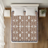 Idia Geometric Cotton Throw Blanket in Rust Brown, on a bed