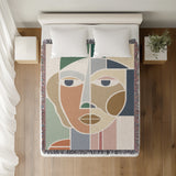 Ira Abstract Face Cotton Throw Blanket, on a bed