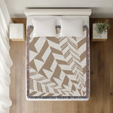 Kafi Abstract Cotton Throw Blanket in Beige, on a bed