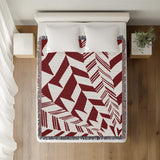 Kafi Abstract Cotton Throw Blanket in Red, on a bed