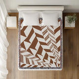 Kafi Abstract Cotton Throw Blanket in Rust Brown, on a bed