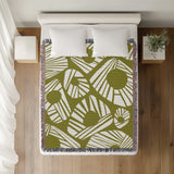Kio Abstract Print Cotton Throw Blanket in Chartreuse, on a bed