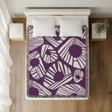 Kio Abstract Print Cotton Throw Blanket in Purple, on a bed