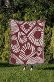 Kio Abstract Print Cotton Throw Blanket in Red, outdoors