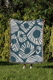 Kio Abstract Print Cotton Throw Blanket in Teal, outdoors