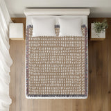 Kola Abstract Print Cotton Throw Blanket in Beige, on a bed