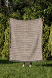Kola Abstract Print Cotton Throw Blanket in Beige, outdoors