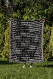 Kola Abstract Print Cotton Throw Blanket in Black, outdoors