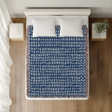 Kola Abstract Print Cotton Throw Blanket in Blue, on a bed