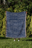 Kola Abstract Print Cotton Throw Blanket in Blue, outdoors