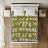 Kola Abstract Print Cotton Throw Blanket in Chartreuse, on a bed
