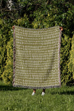 Kola Abstract Print Cotton Throw Blanket in Chartreuse, outdoors