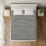 Kola Abstract Print Cotton Throw Blanket in Gray, on a bed