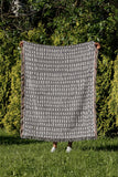 Kola Abstract Print Cotton Throw Blanket in Gray, outdoors