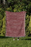 Kola Abstract Print Cotton Throw Blanket in Red, outdoors