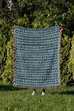 Kola Abstract Print Cotton Throw Blanket in Teal, outdoors