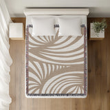 Konga Hand Woven Throw Blanket in Beige, on a bed