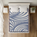 Konga Hand Woven Throw Blanket in Light Blue, on a bed