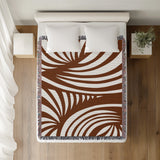 Konga Hand Woven Throw Blanket in Rust Brown, on a bed