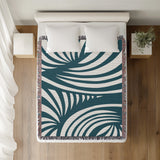 Konga Hand Woven Throw Blanket in Teal, on a bed