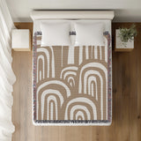 Lyno Abstract Print Cotton Throw Blanket in Beige, on a bed