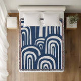 Lyno Abstract Print Cotton Throw Blanket in Blue, on a bed