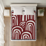 Lyno Abstract Print Cotton Throw Blanket in Red, on a bed