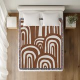Lyno Abstract Print Cotton Throw Blanket in Rust Brown, on a bed