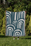 Lyno Abstract Print Cotton Throw Blanket in Teal, outdoors