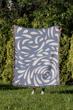 Nami Abstract Floral Blanket Throw in Light Blue, outdoors