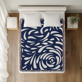Nami Abstract Floral Blanket Throw in Navy Blue, on a bed