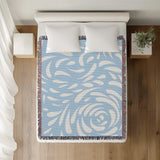 Nami Abstract Floral Blanket Throw in Sky Blue, on a bed